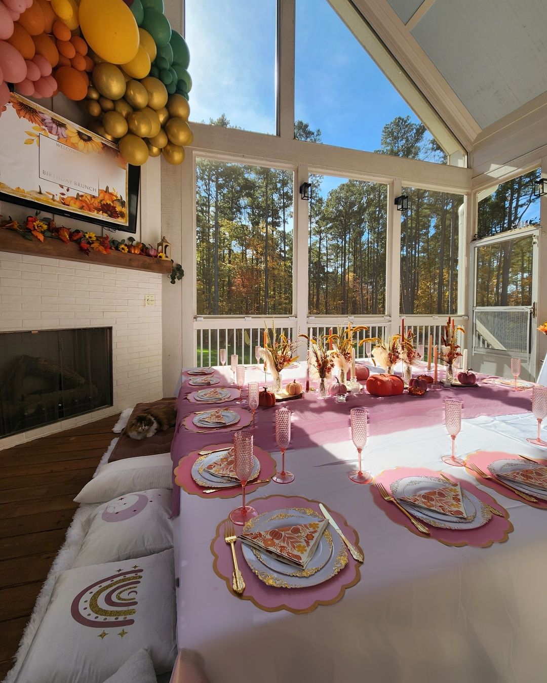 Sunlit fall porch table with a mauve runner, pink chargers and pumpkins