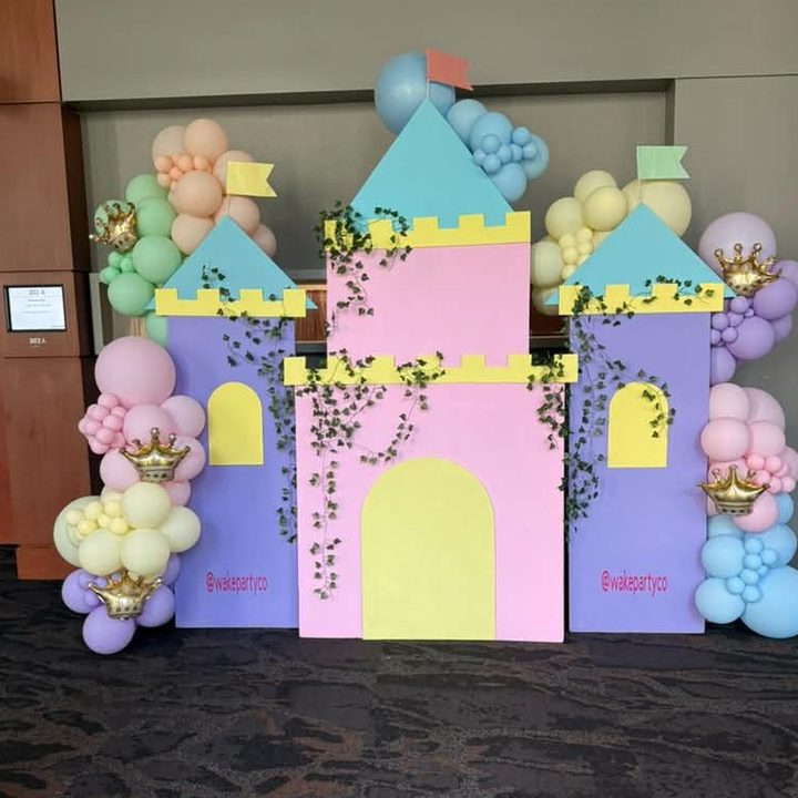 Pastel castle backdrop prop rental with balloon garland and gold crowns by Wake Party Co in Raleigh, NC