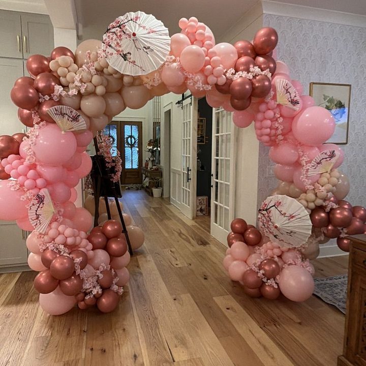 Blush and rose-gold organic balloon arch with cherry blossom parasols in Raleigh, NC