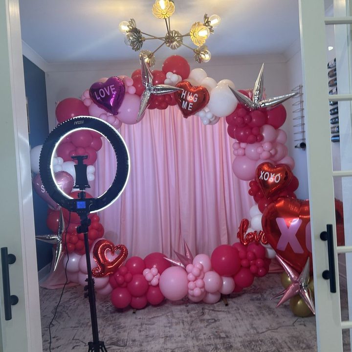 Round backdrop with pink drape and a pink, red and white organic Valentine balloon garland in Wake Forest, NC