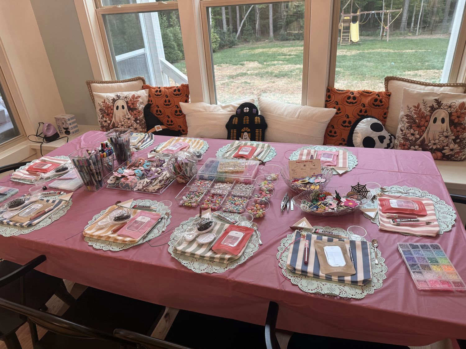 Rose tablecloth with doilies and striped place settings for a party